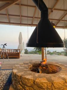 eine schwarze Glocke, die über einer Feuerstelle hängt in der Unterkunft Beso Patara in Patara