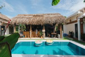uma villa com uma piscina e uma cabana de palha em Wanderlust em An Bàn (2)