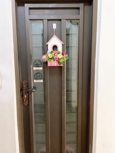 a door with a pink birdhouse and flowers on it at Warm Fengjia LesGo in Taichung