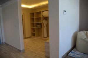 Cette chambre dispose d'un placard avec des murs blancs et du parquet. dans l'établissement Fantazia Resort Marsa Alam, à Marsa Alam