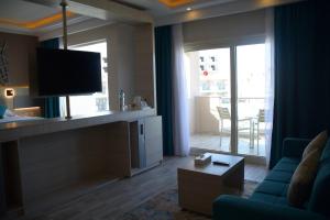 Fantazia Resort Marsa Alam في مرسى علم: غرفة معيشة مع أريكة زرقاء وتلفزيون