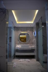 La salle de bains est pourvue d'une baignoire et d'un grand miroir. dans l'établissement Fantazia Resort Marsa Alam, à Marsa Alam