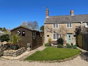 a detached house with a garden and a shed at Cottage en-suite room with private lounge in Bridport