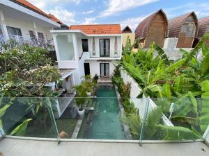 a courtyard with a swimming pool in front of a house at Villa Kalma Canggu in Canggu