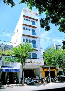 Khách Sạn LUCIEN HOTEL Quy Nhơn في كوي نون: مبنى طويل وبه دراجات نارية متوقفة أمامه
