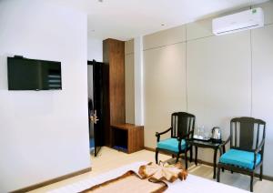 a room with two chairs and a table and a tv at Khách Sạn LUCIEN HOTEL Quy Nhơn in Quy Nhon