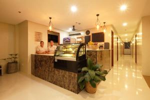 two people standing at a counter in a restaurant at Jai-cob’s Suites in Coron