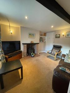 a living room with a tv and a fireplace at Cottage en-suite room with private lounge in Bridport