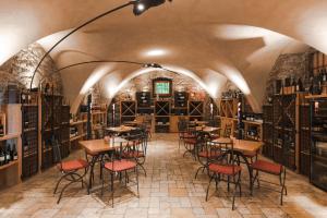 une chambre avec des tables et des chaises dans une cave à vin dans l'établissement Hotel Mandelhof ***S, à Appiano sulla Strada del Vino