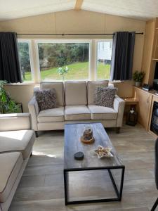 a living room with a couch and a coffee table at Percy Wood Lodge with Hot Tub near Alnwick in Swarland