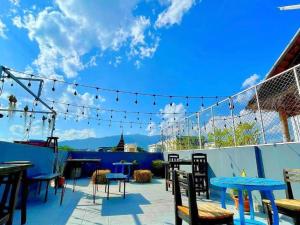 un patio con tavoli, sedie e cielo azzurro di Newnormal Hotel a Chiang Mai
