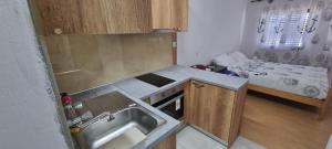 - une petite cuisine avec un évier et un lit dans l'établissement Bradley apartmants HR, à Račišće