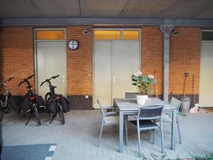 - une terrasse avec une table, des chaises et des motos dans l'établissement BenB Op de Trans, Arnhem op zijn best!, à Arnhem