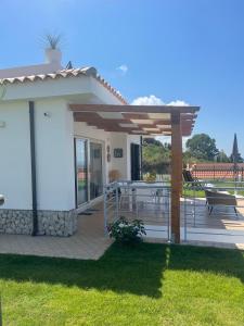 a house with a deck with a pergola at Villa Sofia *Luxury experience in Calabria in Zambrone