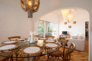 una sala da pranzo con tavolo e sedie di Villa Margarita 85 With Expectacular see Views a Son Bou