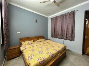 una camera da letto con un letto e un piumone giallo di Entire floor 2BHK with full Kitchen Near Medanta hospital a Gurgaon