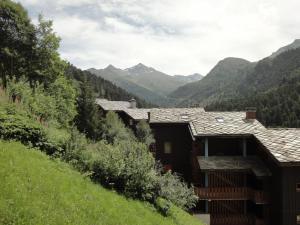 a house on a hill with mountains in the background at Apartment Sérac in Méribel