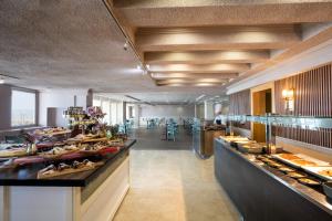 a restaurant with a buffet line with food at Leonardo Gordon Beach in Tel Aviv