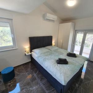 - une chambre dotée d'un lit avec deux objets noirs dans l'établissement Villa BOTIĆ, à Trogir