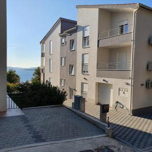 an apartment building with a parking lot in front of it at Villa BOTIĆ in Trogir