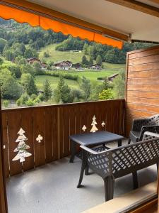 einen Balkon mit einem Tisch und Blick auf einen Hügel in der Unterkunft Studio , Val-d’Illiez in Val dʼIlliez