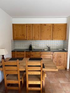 a kitchen with a wooden table and wooden cabinets at Studio , Val-d’Illiez in Val-d'Illiez