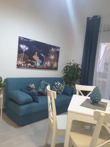 sala de estar con sofá azul y mesa en A casa dei 3, en Catania