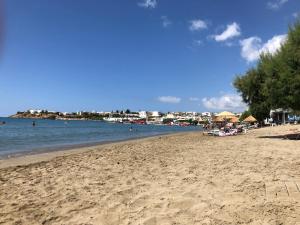piaszczysta plaża z ludźmi pływającymi w wodzie w obiekcie Blue Sky Apartments w mieście Makry Gialos +21 zdjęć