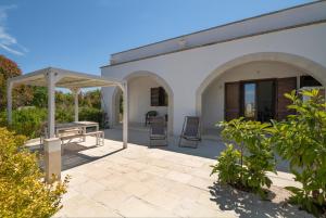 a patio of a house with a table and chairs at Podere Santa Chiara in Otranto