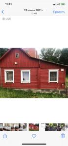 un fienile rosso con due finestre sul lato di dom polnostju a Krāslava