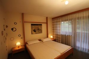 a bedroom with a bed and a window and two lamps at Residence Ben Ste in Ortisei