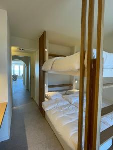 a bedroom with two bunk beds and a hallway at Zeedijk Oostduinkerke frontaal zeezicht - volledig gerenoveerd 2022! in Oostduinkerke