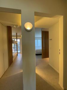 un couloir avec une chambre avec un lit et une lumière dans l'établissement Zeedijk Oostduinkerke frontaal zeezicht - volledig gerenoveerd 2022!, à Oostduinkerke