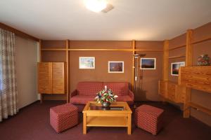 a living room with a red chair and a table at Residence Ben Ste in Ortisei