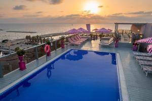 a pool on the roof of a resort with the ocean at Leonardo Gordon Beach in Tel Aviv