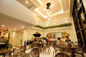 a group of people sitting at tables in a restaurant at Jai-cob’s Suites in Coron