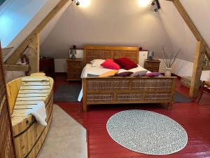 um quarto com uma cama com almofadas vermelhas em chambres d'hôtes et Gîte Le Moulin Sainte Marie em Estrée-Wamin