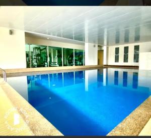 a large swimming pool with blue water in a building at KLCC Amazing Robots Homestay 4Bedrooms (13pax) in Kuala Lumpur