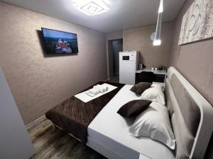 a room with a bed and a tv on the wall at Kharkovlux in Kharkiv