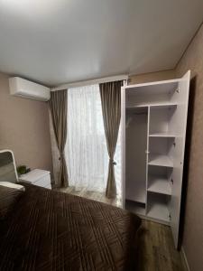 1 dormitorio con cama y ventana grande en Kharkovlux en Járkov