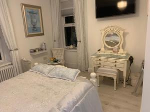 a bedroom with a bed and a dresser and a mirror at Coastal Joy - Room 5 in Newbiggin-by-the-Sea