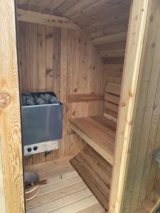 una pequeña sauna de madera con estufa. en Coastal Joy - Room 5, en Newbiggin-by-the-Sea
