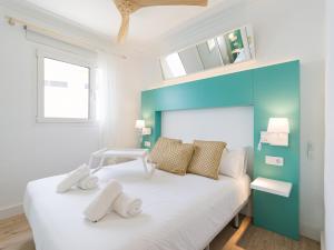 Schlafzimmer mit einem großen weißen Bett mit blauem Kopfteil in der Unterkunft Viewpoint Over The Cliff By CanariasGetaway in Maspalomas