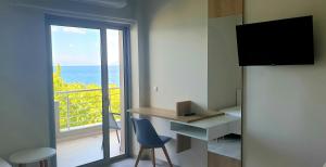 a room with a desk and a view of the ocean at Mangata Seaside Hotel in Rovies