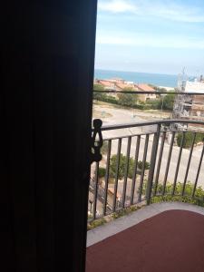 - une porte donnant sur un balcon avec vue sur l'océan dans l'établissement "La Gardenia" Affittacamere, à Marina di Montemarciano