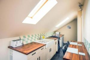 eine Küche mit weißen Schränken und einem Dachfenster in der Unterkunft 1 Bedroom Annexe Bagthorpe Brook Nottinghamshire in Nottingham