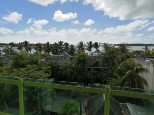 a view from the balcony of a resort with palm trees at Hypertek Guesthouse in Grand Baie