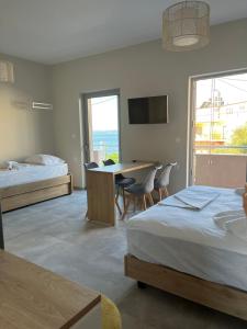 ロビエスにあるMangata Seaside Hotelのベッド2台、テーブル、デスクが備わる客室です。
