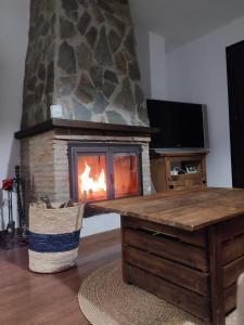 - une cheminée en pierre dans un salon avec une table et une cheminée dans l'établissement La Castaña y la Uva, 