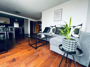 salon z kanapą i stołem z rośliną w obiekcie 2 Bedroom Penthouse Birmingham w Birmingham